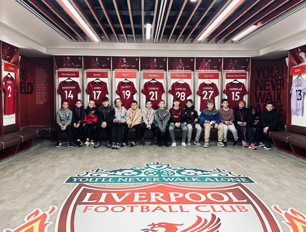 The travel group seated together in the Liverpool dressing room during the England 2023 trip