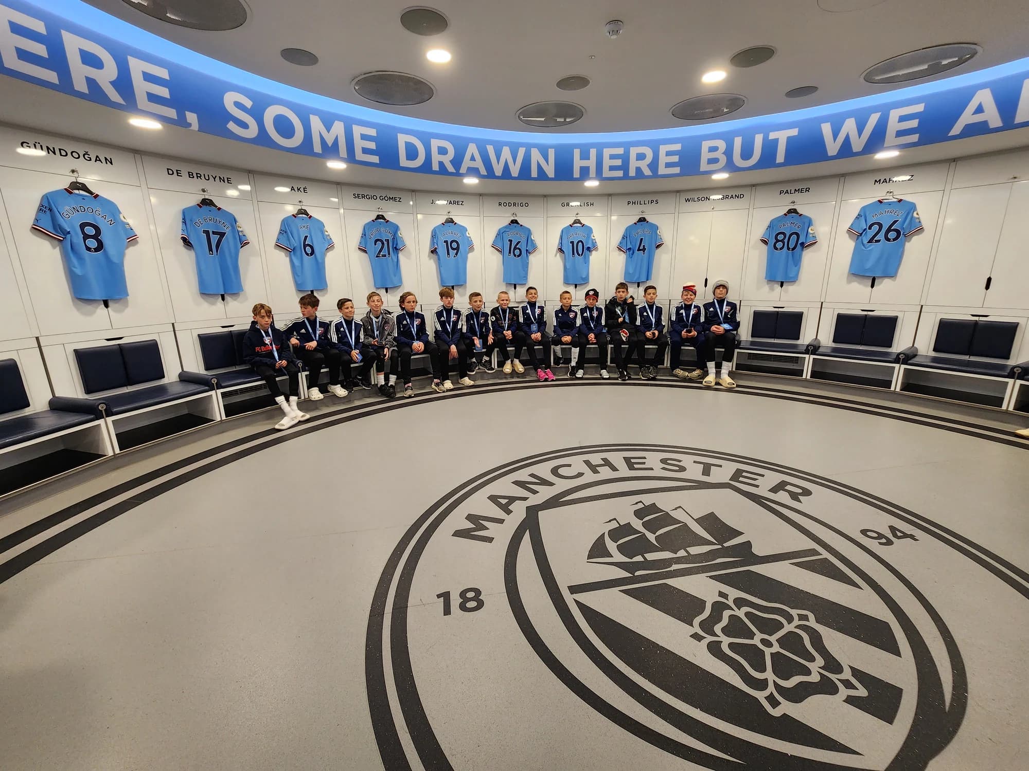 The team seated in Manchester City’s locker room during the England 2023 trip